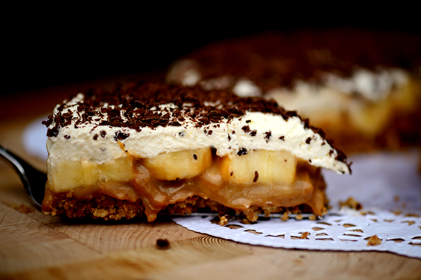 Ein Stück Banoffee Pie besteht aus einem hellbraunen Hafterkeksboden, einer verführerischen Karamellschicht, jeder Menge Bananen und einem feinen Schlagobers-Schokostreusel-Häubchen. Zum Anbeißen!